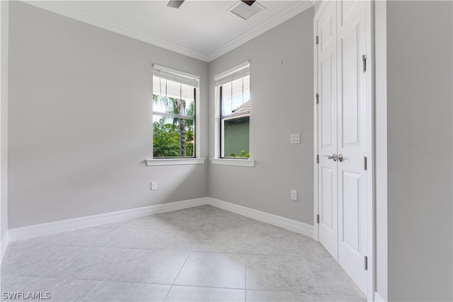 tiled spare room with ornamental molding