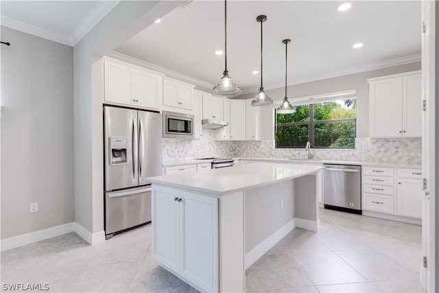 kitchen featuring stainless steel appliances, a center island, ornamental molding, white cabinets, and sink