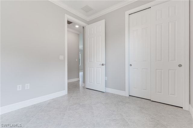 unfurnished bedroom with a closet, ornamental molding, and light tile patterned floors