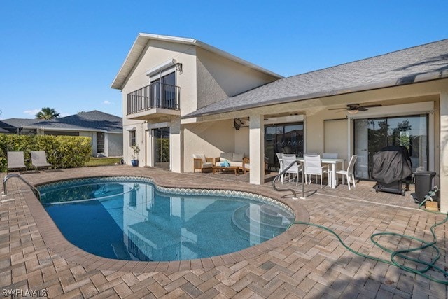 view of swimming pool with ceiling fan and a patio