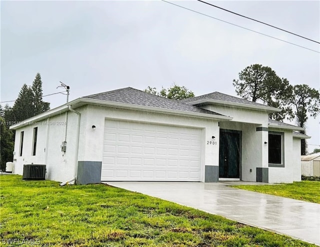 view of front facade with a garage, a front yard, and cooling unit