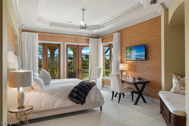 bedroom featuring access to exterior, a tray ceiling, crown molding, light carpet, and french doors