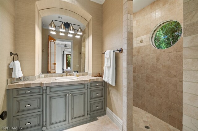 bathroom featuring vanity, tiled shower, and tile patterned floors