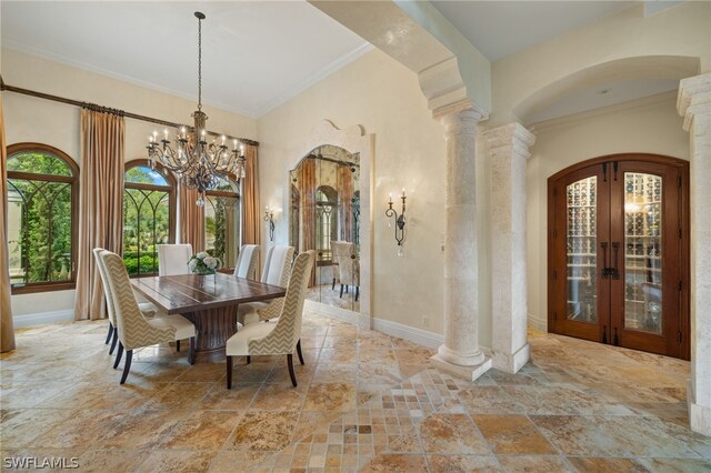 dining room featuring an inviting chandelier, ornamental molding, decorative columns, and french doors