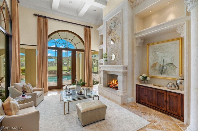 sitting room featuring beam ceiling, a high ceiling, coffered ceiling, ornamental molding, and a tiled fireplace