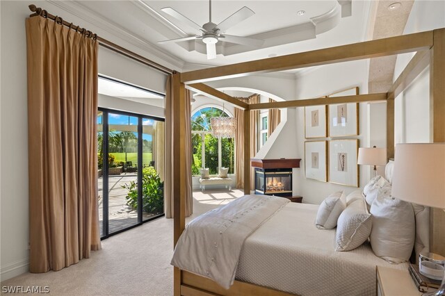 carpeted bedroom featuring ornamental molding, access to exterior, and a raised ceiling