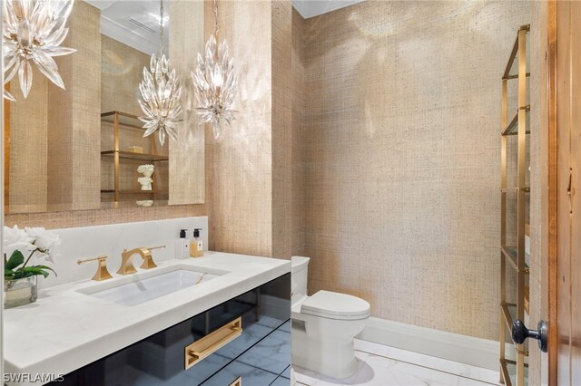 bathroom featuring vanity, toilet, and a chandelier