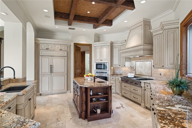 kitchen featuring custom exhaust hood, light stone countertops, cream cabinets, and sink