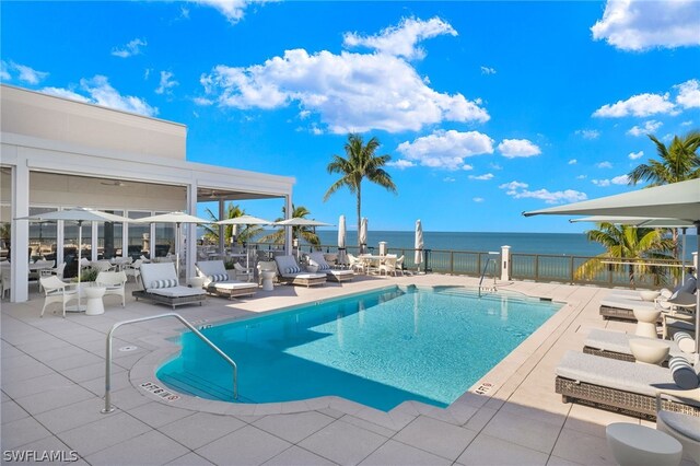 view of swimming pool with a patio area and a water view