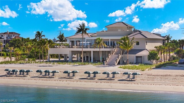 back of house featuring a beach view and a water view