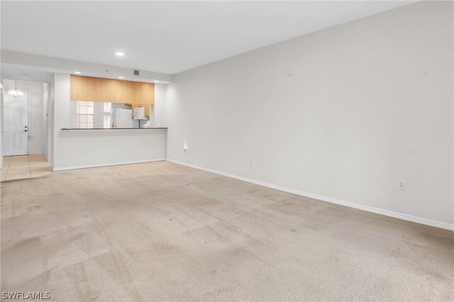 unfurnished living room featuring light colored carpet