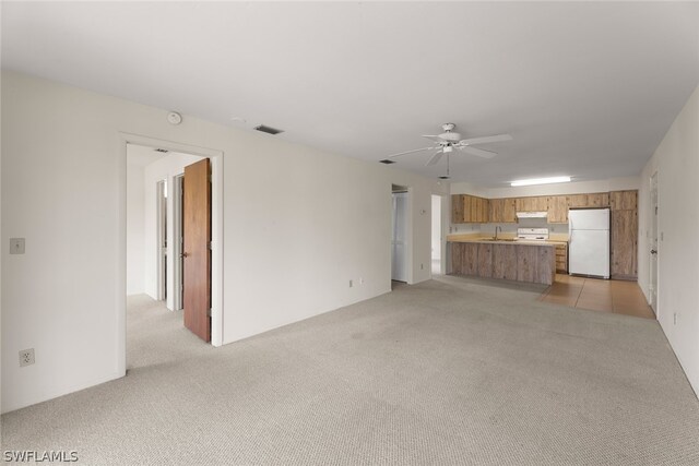 unfurnished living room with light carpet and ceiling fan