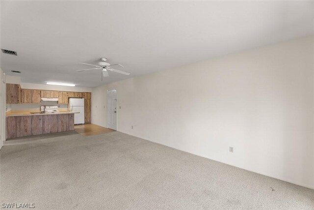 unfurnished living room with light colored carpet and ceiling fan