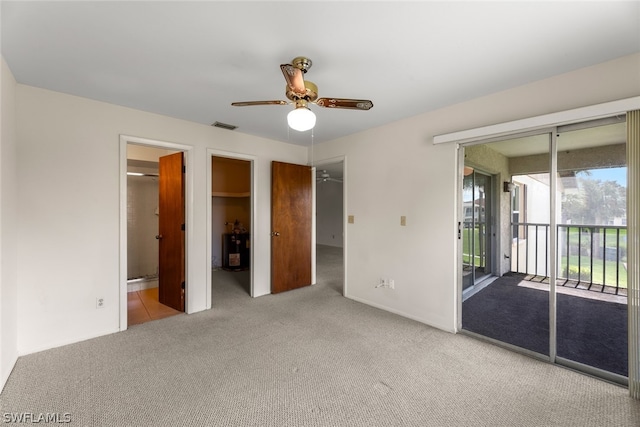 unfurnished bedroom featuring access to outside, light colored carpet, ensuite bathroom, and ceiling fan