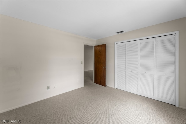 unfurnished bedroom with carpet flooring and a closet