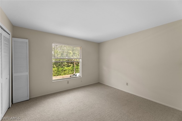 unfurnished bedroom featuring carpet flooring and a closet