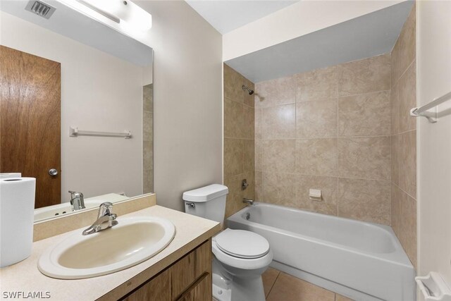 full bathroom with vanity, toilet, tiled shower / bath, and tile patterned flooring