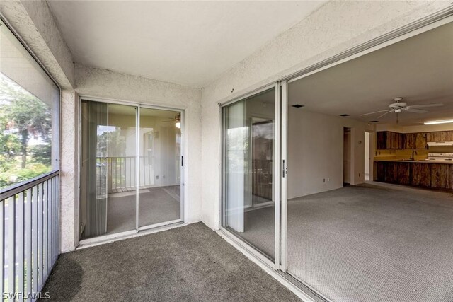 unfurnished sunroom featuring sink and ceiling fan