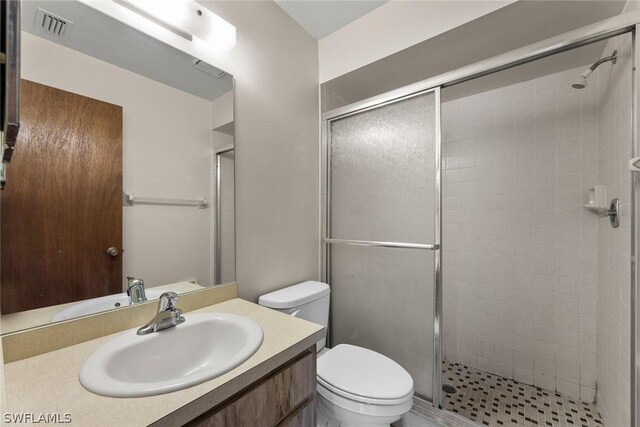 bathroom featuring vanity, toilet, and an enclosed shower