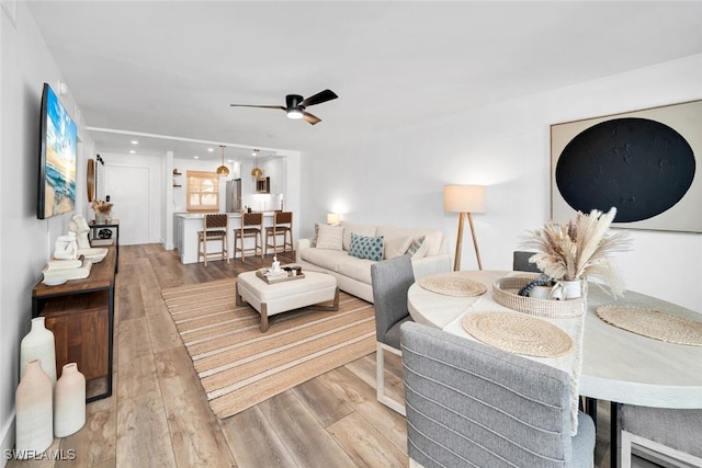 living room featuring light hardwood / wood-style flooring and ceiling fan