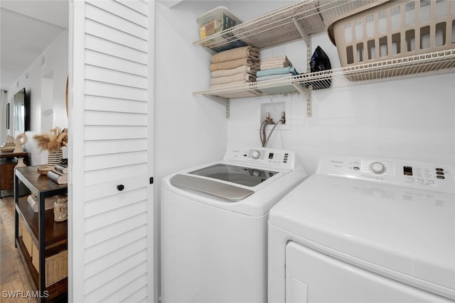 laundry area with washer and clothes dryer and hardwood / wood-style floors