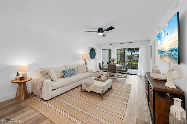 living room with light wood-type flooring and ceiling fan