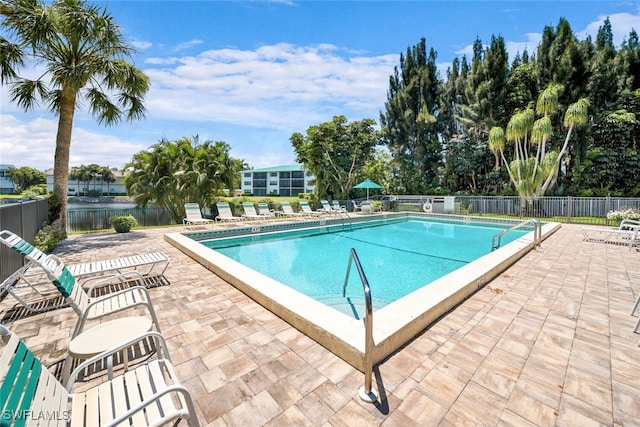 view of pool featuring a water view and a patio