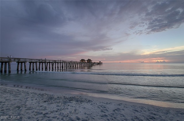 dock area with a water view and a beach view