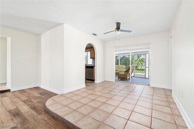 empty room featuring ceiling fan, light hardwood / wood-style floors, and a textured ceiling