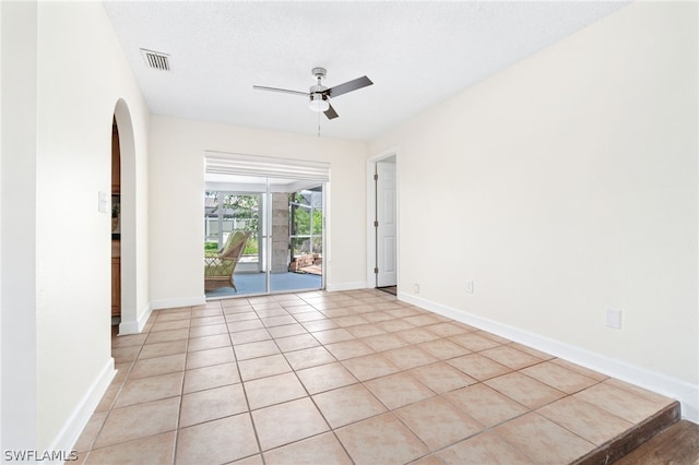 unfurnished room featuring light tile patterned floors, a textured ceiling, and ceiling fan