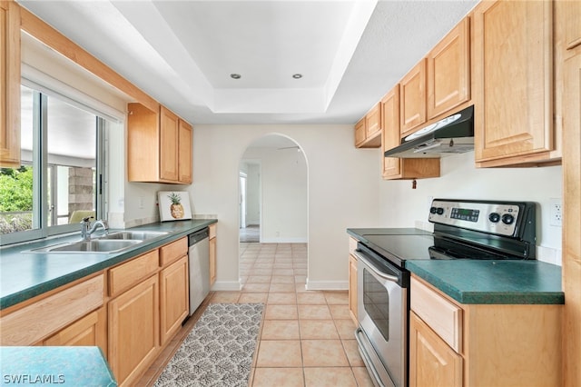 kitchen featuring light tile patterned flooring, sink, light brown cabinets, appliances with stainless steel finishes, and a tray ceiling