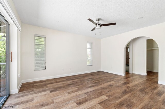 spare room with hardwood / wood-style flooring, a textured ceiling, and ceiling fan