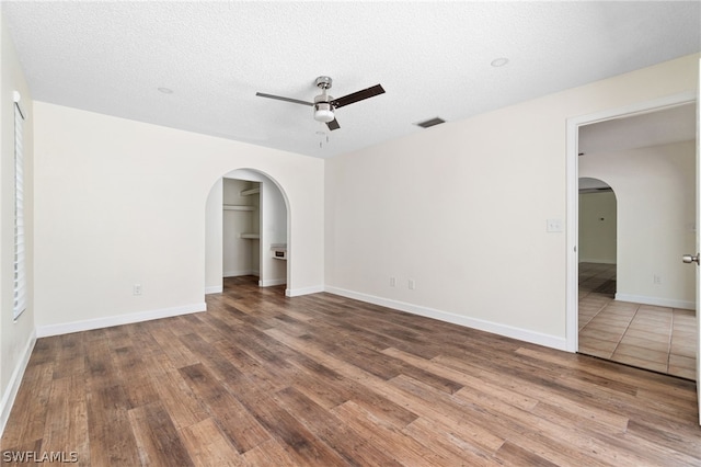 unfurnished room with hardwood / wood-style flooring, a textured ceiling, and ceiling fan