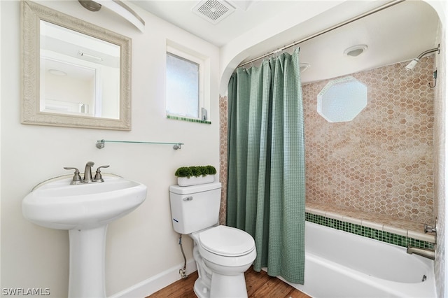 bathroom with radiator, wood-type flooring, shower / bath combo, and toilet