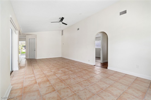 unfurnished room with light tile patterned floors, vaulted ceiling, and ceiling fan