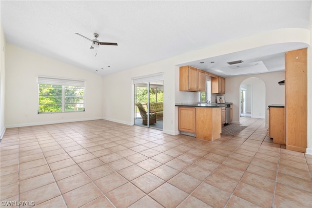 kitchen featuring ceiling fan, sink, vaulted ceiling, and light tile patterned floors