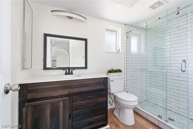 bathroom featuring vanity, hardwood / wood-style floors, an enclosed shower, and toilet