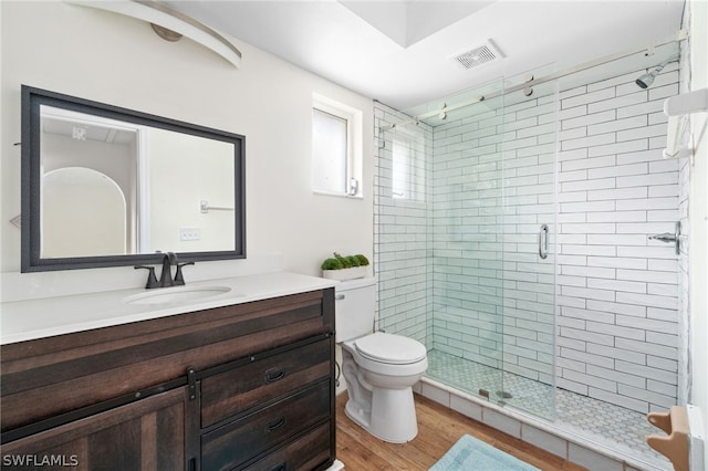 bathroom featuring hardwood / wood-style flooring, vanity, an enclosed shower, and toilet