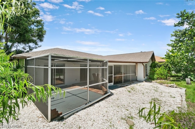 back of property featuring glass enclosure and a patio area