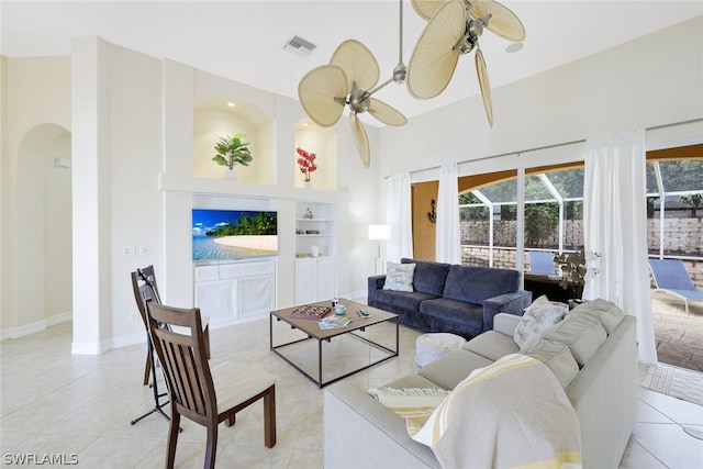 living room featuring built in features, light tile patterned floors, and ceiling fan