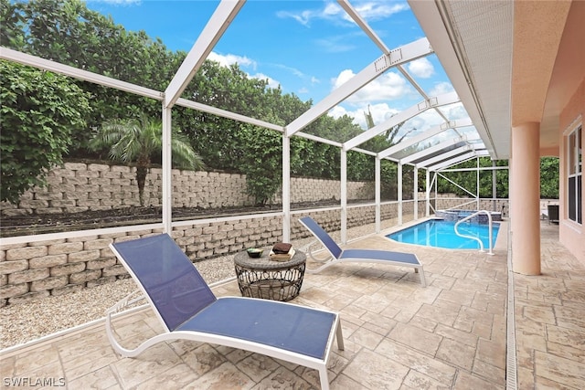 view of pool with a patio and glass enclosure