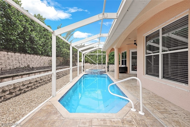 view of swimming pool with an in ground hot tub, ceiling fan, glass enclosure, and a patio area