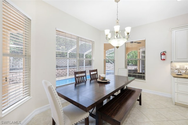 dining room with light tile patterned floors and a notable chandelier