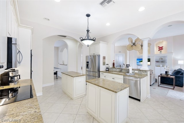 kitchen featuring sink, a center island, kitchen peninsula, pendant lighting, and stainless steel appliances