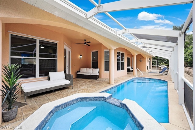 view of pool with ceiling fan, glass enclosure, and a patio area