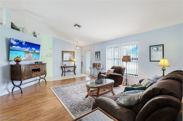 living room featuring light hardwood / wood-style flooring and lofted ceiling