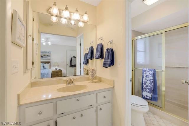 bathroom featuring tile patterned floors, vanity, ceiling fan, toilet, and a shower with door