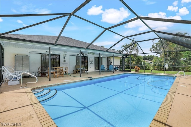 view of swimming pool featuring ceiling fan, a lanai, and a patio area