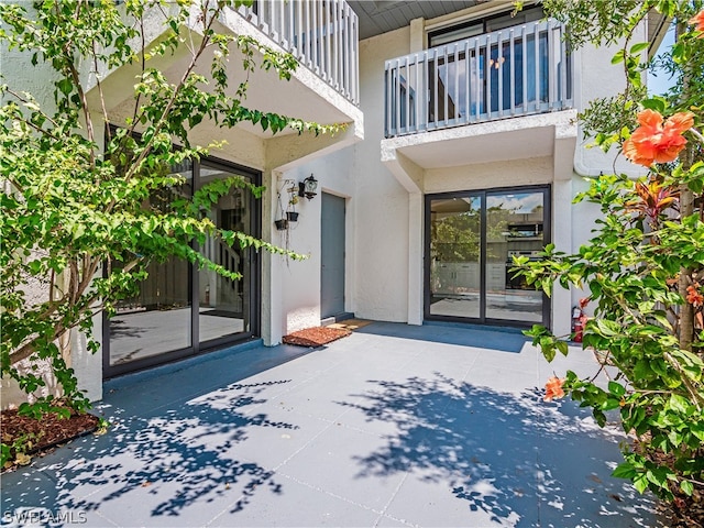 entrance to property with a balcony and a patio