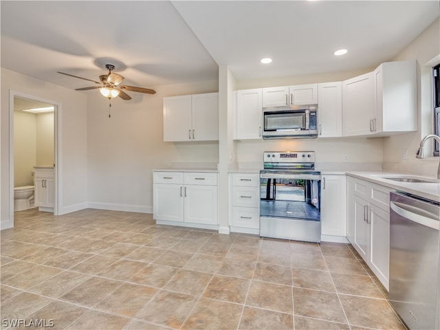 kitchen featuring white cabinetry, ceiling fan, stainless steel appliances, sink, and light tile patterned floors